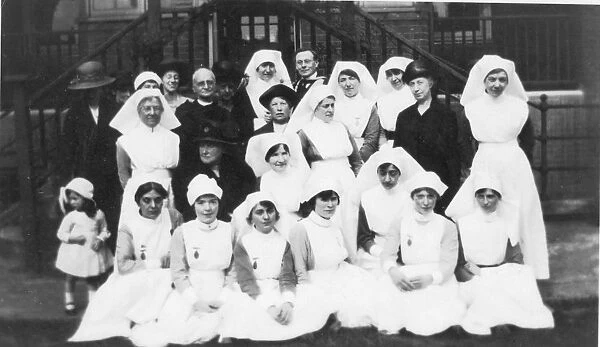 Group of nurses, older ladies, cleric and little girl