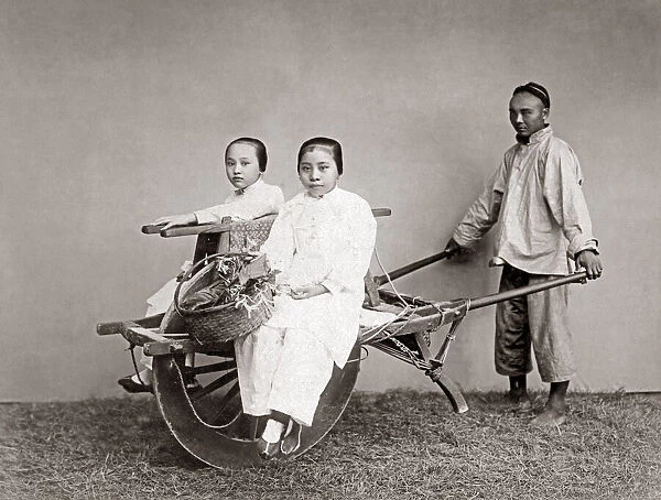 Women on a wheelbarow, China, circa 1880s. Date: circa 1880s