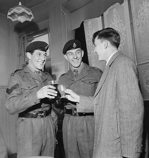 British pop singer Terry Dene (right) enjoys a drink with Corporal B Goodall (left