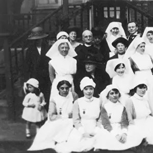 Group of nurses, older ladies, cleric and little girl