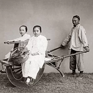 Women on a wheelbarow, China, circa 1880s. Date: circa 1880s