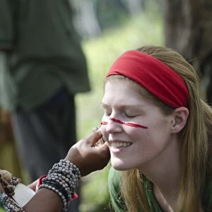 Tourist having her face painted at Sing-sing - The Paiya Show in Western Highlands