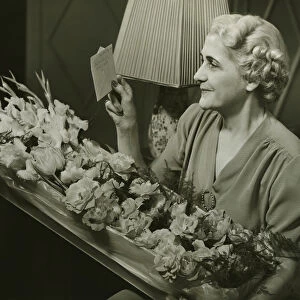 Mature woman receiving box of flowers, (B&W)