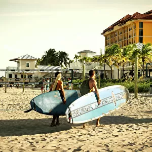 Florida, Deerfield Beach, two surfers walking on beach